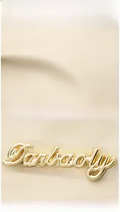 Close-up of beige nylon fabric texture and golden Darbaoly metal logo detail