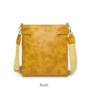 Back view of yellow PU leather crossbody bag with ethnic style woven shoulder strap