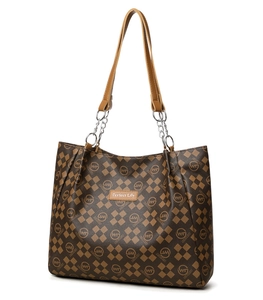 Détail du cabas à damier marron avec écusson en cuir et poignée en chaîne métallique