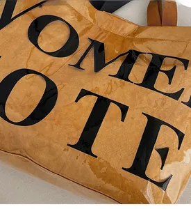 Close-up of waterproof textured tote bag in brown with large black TOTE lettering detail