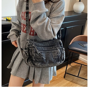 Gros plan du sac en denim délavé avec poches zippées et texture style urbain robuste