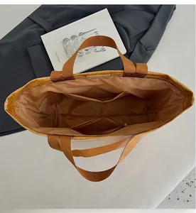 Internal view showing compartments and zipper pocket of the khaki tote bag