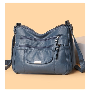 Detailed view of dark blue soft washed leather bag showing zippers and litchi texture