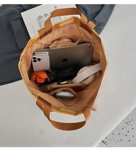 Spacious interior of brown tote bag holding iPad, headphones, and daily essentials