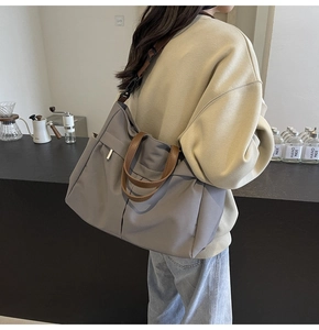 Vue latérale du grand sac cabas en nylon gris clair avec poignées marron et sangle