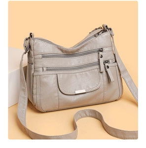 Detail of light gray multi-pocket crossbody bag with soft washed leather texture