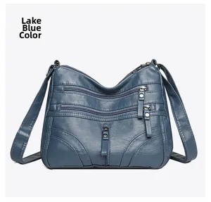 Detailed view of lake blue soft leather crossbody bag with multiple front zippers