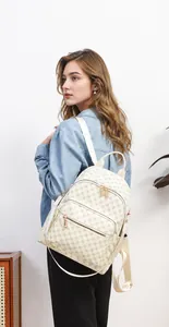 Zaino crema chic con stampa vintage e cerniere dorate indossato da una modella