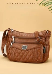 Detailed view of brown quilted PU leather bag with silver zippers and multi-compartment design
