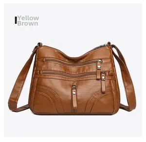 Detail of yellow brown soft leather crossbody bag with multiple functional zippers