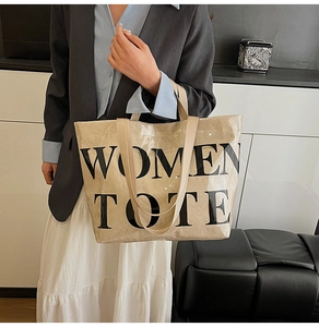 Detail of transparent PVC tote bag with beige inner layer and WOMEN TOTE text print