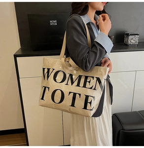 Detail of beige tote bag with WOMEN TOTE print and crinkled waterproof texture