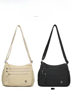 Front detail of nylon crossbody bags in khaki and black with multi-layer zipper pockets
