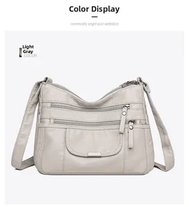 Detailed view of light gray multi-pocket soft faux leather crossbody bag with silver zippers