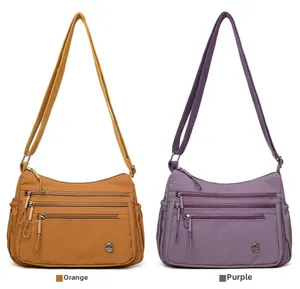 Detail of multi-pocket nylon crossbody bag showing orange and purple color options