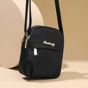 Minimalist black nylon mini crossbody phone bag with gold zipper and metal logo