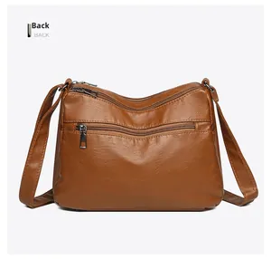 Detail view of the brown leather crossbody bag back showing a secure zipper pocket