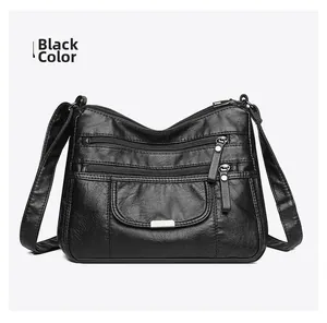 Detailed view of black washed leather crossbody bag with multiple zippers and pockets