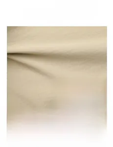 Detail of beige high-density fabric texture and silver M-letter metal logo on tote bag