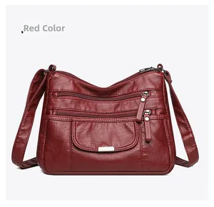 Close-up of red washed leather crossbody bag with multiple zippers and litchi texture