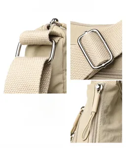 Detailed macro view of electroplated metal hardware and smooth nylon fabric on tote bag