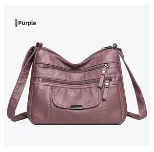Detail view of purple washed faux leather crossbody bag with multiple zip pockets
