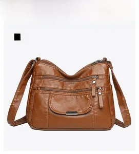 Front view of brown washed soft leather crossbody bag with multi-zipper pockets