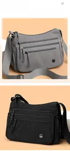 Detail view of multi-zipper waterproof nylon crossbody bag in gray and black colors
