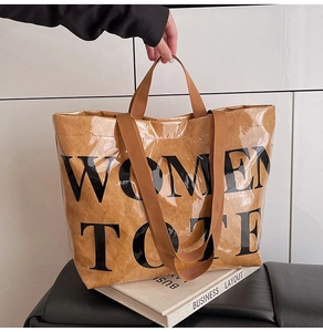 Detail of transparent PVC tote bag with brown inner liner and black Women Tote text