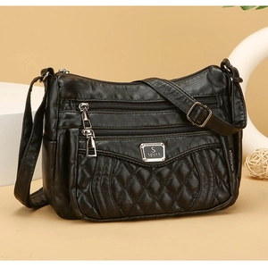 Close-up of black quilted PU leather crossbody bag with triple zipper pockets and metal logo