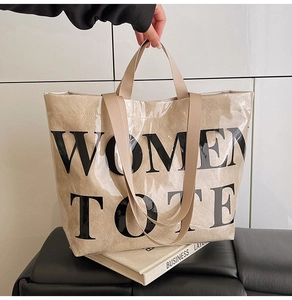 Detail of transparent PVC tote bag with Women Tote text and brown leather interior