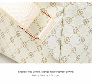 Dettaglio del rinforzo a triangolo e fibbia dorata su uno zaino in pelle beige