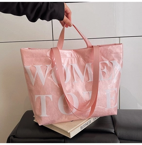 Close-up of pink fabric tote bag with transparent PVC layer and white lettering