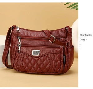Detailed close-up of dark red quilted PU leather shoulder bag with multiple zip pockets