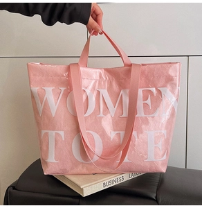 Detailed texture of pink crinkled tote bag with Women Tote print and woven handles