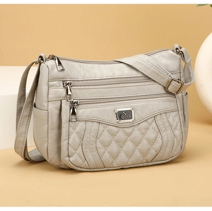 Close-up of light grey quilted PU leather crossbody bag with multiple zippers and S sport logo