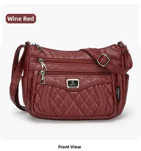 Front detail of wine red quilted PU leather crossbody bag with multiple zippers