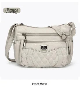 Detail view of grey faux leather crossbody bag with quilted texture and multi-pocket design