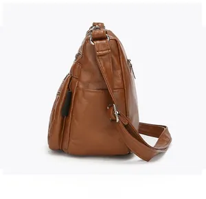Side view of brown PU leather crossbody bag showing layered pockets and adjustable strap