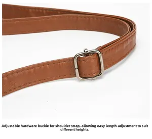Detail of adjustable brown leather shoulder strap with silver metal buckle on a handbag