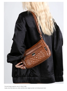 Close-up of brown quilted leather crossbody bag with multiple zippers and spacious interior
