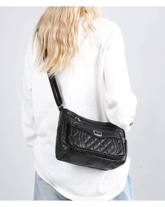 Quilted black crossbody bag with multiple zippers shown on model for size and fit