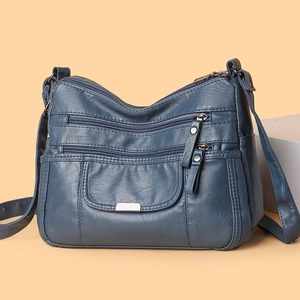 Navy blue soft leather crossbody bag with multiple zippers and adjustable shoulder strap