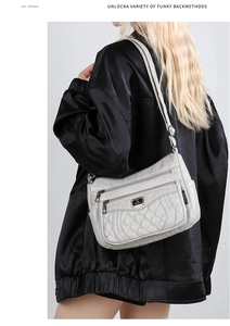 Close-up of light gray quilted PU leather bag with multi-zipper pockets and long strap