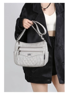 Detail view of light gray multi-pocket shoulder bag with quilted diamond pattern