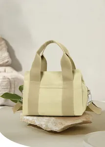 Detail of vintage canvas tote bag with adjustable shoulder strap on natural stone background