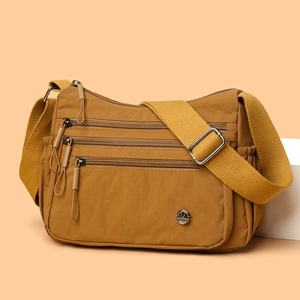 Minimalist mustard yellow crossbody tote bag with three front zippers and wide strap