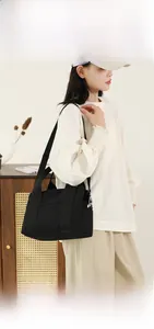 Detail view of black canvas tote bag showing A4 magazine capacity and breathable material