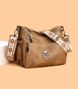 Close-up of vintage brown tote bag with metallic kangaroo logo and floral wide strap