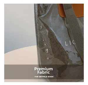 Détail de tissu à motif marbré avec coutures en cuir marron et logo LIG sur le côté du sac